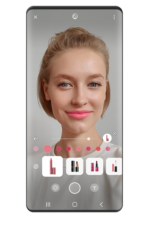 Se muestra una mujer usando efectos de labial rosa y varias miniaturas de productos labiales en la imagen con la función AR de Bixby Visión.