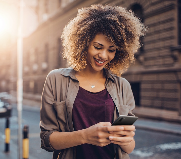 Жінка шукає фотографію в додатку «Галерея» за допомогою Bixby під час вечірки.