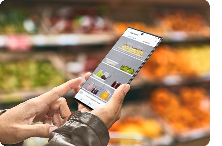 Користувач Galaxy перевіряє вміст холодильника за допомогою програми SmartThings , перебуваючи в магазині.