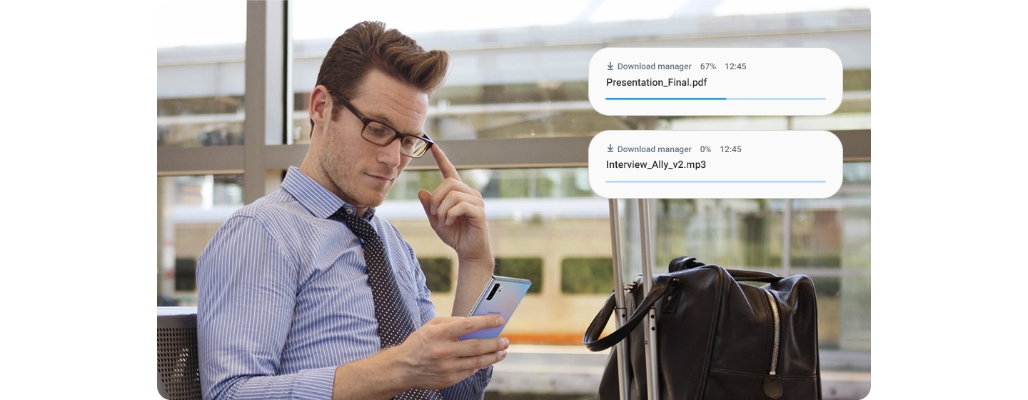 Man holding Galaxy Note10+. Download manager notifications appear showing two items being downloaded at the same time thanks to the improved data speeds.