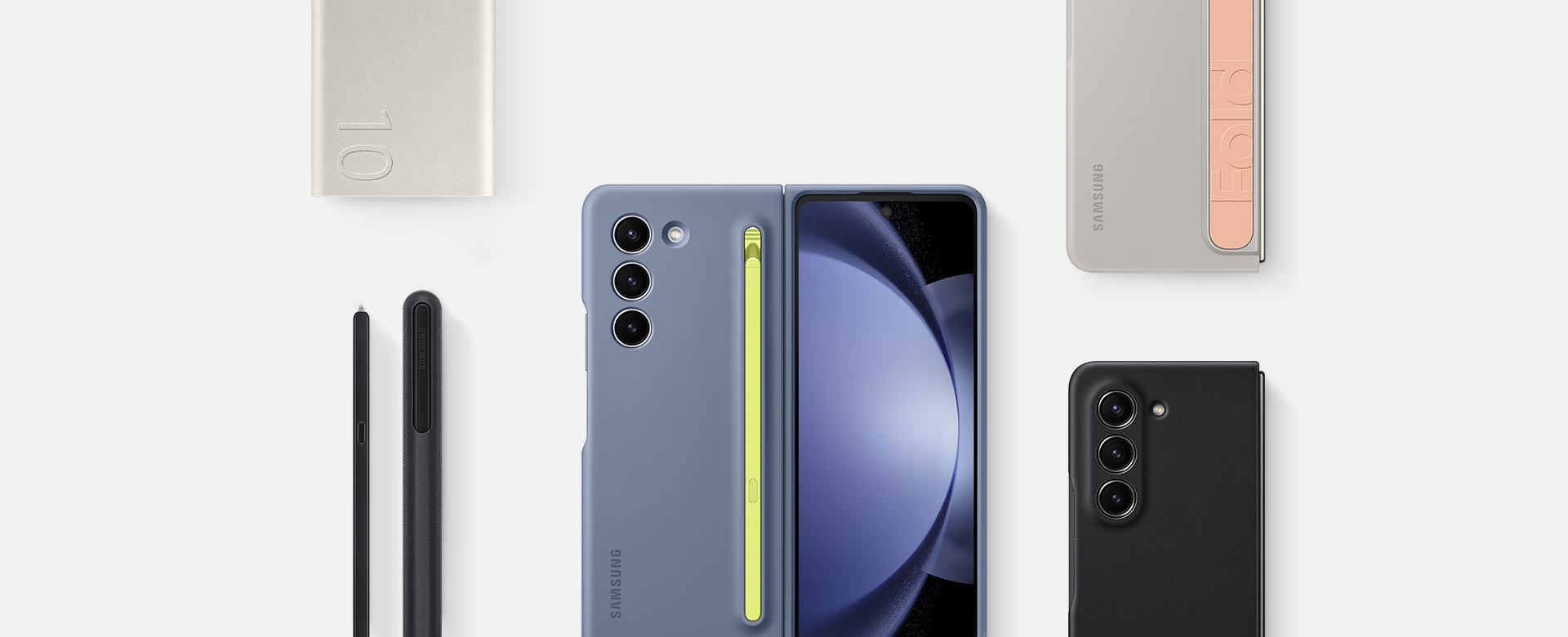 صورة مسطحة لملحقات مخصصة لهاتف Galaxy Z Fold5: مجموعة البطارية، قلم S Pen Fold Edition لهاتف Galaxy Z Fold5 وثلاثة أجهزة تم تركيب حافظات لها، بما في ذلك غطاء قلم S Pen نحيف بلون Icy Blue وغطاء بمسند وحزام بلون Sand وغطاء جلدي صديق للبيئة بلون Black.