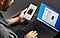 An over-the-shoulder shot of a man holding a Galaxy Note10 in his left hand and using the trackpad of a Galaxy Book S in his right, there are messages on both screens