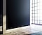 A bezel-less, seamless The Wall display mounted right up against a simple beige wall to show the slimness of the screen
