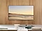 Installed on the wall of a living room, The Frame displays a peaceful scene of a seashore.