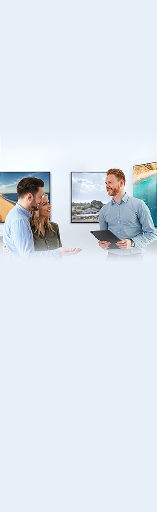 For buying a new TV, a man and woman are talking with a male sales representative about TV  features in a TV show room.
