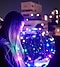 Photographie de nuit d’été d’une femme tenant un ballon LED lumineux avec des lumières bokeh en arrière-plan