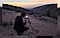 Un photographe sur une crête prépare une photo à l’aide de son Samsung Galaxy S22 et d’un trépied.
