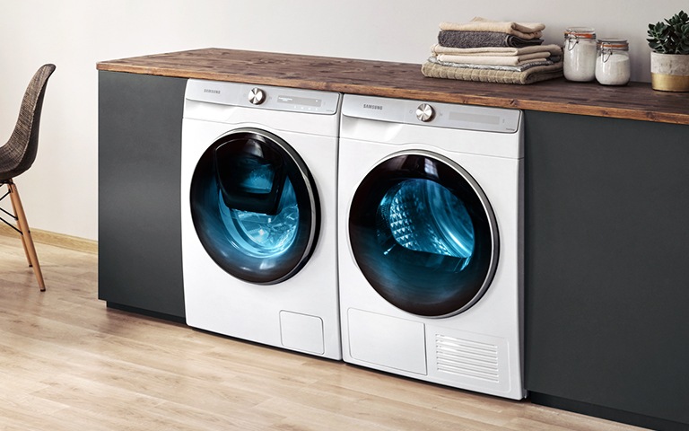Nën banakun e zi, gjendet kombinimi i makinës larëse dhe tharëse të re Samsung.
