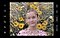 La pantalla de un Galaxy S21 Ultra 5G muestra un retrato de una nena frente a unas flores amarillas tomado a través de gotas de agua. Las gotas de agua están resaltadas por un símbolo circular, lo que indica que deben estar enfocadas.