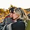 Foto romántica tomada de un lado que muestra a una pareja bajo una manta en el desierto