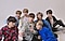 BTS tomandóse una selfie grupal. Todos están sentados en el piso y posando con el S20+ que sostiene Jung Kook.