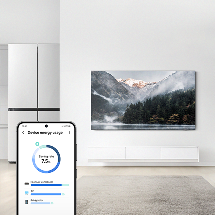 Sala de estar moderna con heladera de acero inoxidable, aire acondicionado montado en la pared y televisor de pantalla plana con vistas panorámicas a la montaña. La pantalla de un teléfono inteligente muestra la función “Uso de la energía del dispositivo” con un informe de ahorro energético que indica una reducción del 7,5 % en el consumo.