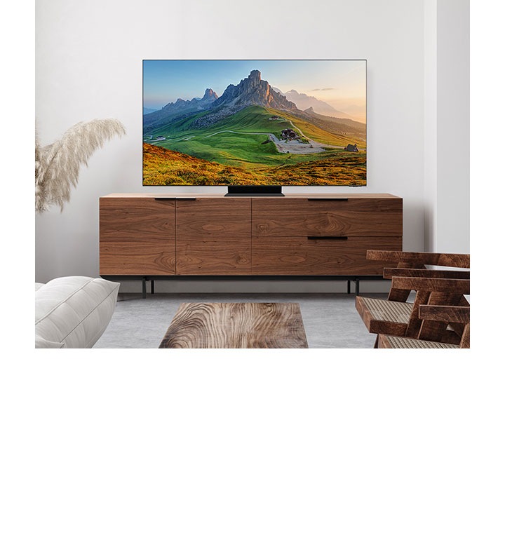 Una pantalla Samsung está colocada en un soporte y muestra una imagen de montañas.