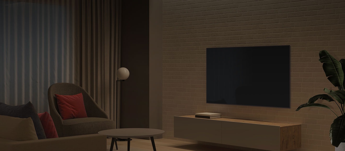 Im Hintergrund ist ein Wohnzimmer zu sehen, der TV und das Licht sind ausgeschaltet.