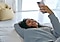 Eine lächelnde Frau liegt auf dem Boden und schaut auf ihr Galaxy S25 Ultra. Hinter ihr ist ein gelber Sitzsack zu sehen.