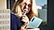 Eine Frau hält einen S Pen an ihre Lippen, während sie auf ihr Galaxy Note10 schaut