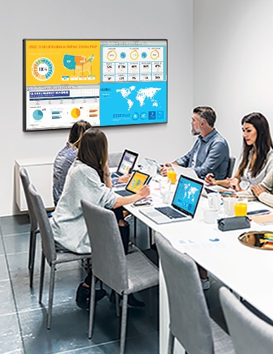 People are sitting in a conference room and watching data from their laptops by QxB. QxB is divided into 4 screens, each showing different information on one screen.