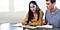 A woman and man sitting side by side, using a Galaxy Tab and S Pen to study together.