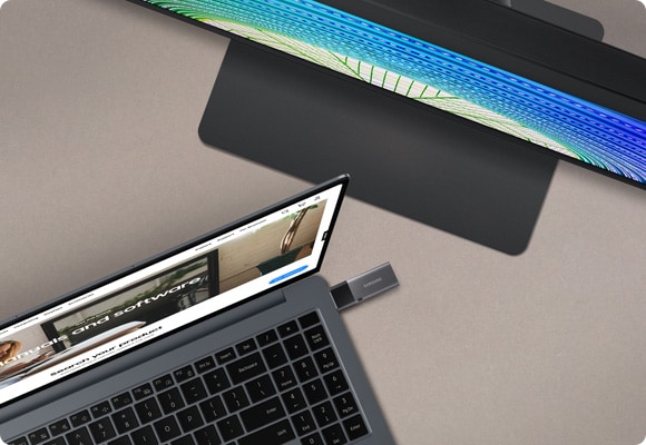 Samsung laptop connected to a monitor with a USB flash drive, displaying software update files.