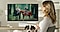 A woman relaxing with her dog while watching a fantasy show on a high-resolution monitor, showcasing sharp image quality and immersive entertainment experience.