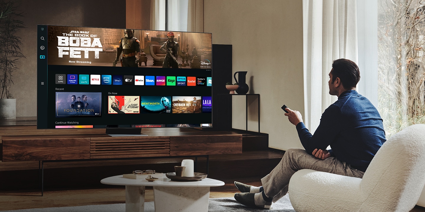 A man is in his living room viewing the new Smart Hub UI on his Neo QLED.