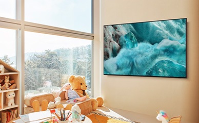 A 98 inch Supersize TV is mounted on a wall in a living room displaying the ocean.