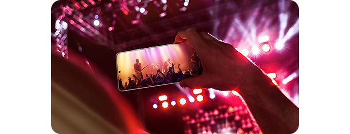 Prikazan je mobilni telefon vertikalno u zraku. Scena koncerta u kojoj muzičar svira gitaru je prikazana na ekranu. Pozornica je prikazana iza telefona.