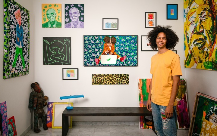 Carl Cash in zijn huis tussen zijn kleurrijke kunstwerken en zijn Samsung The Frame.