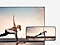 De Galaxy-smartphone en tv met een vrouw die yoga doet.