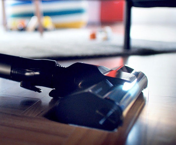 We zien een close-up van de Samsung Jet-stofzuiger op een woonkamervloer met de Slim LED Brush verlicht.