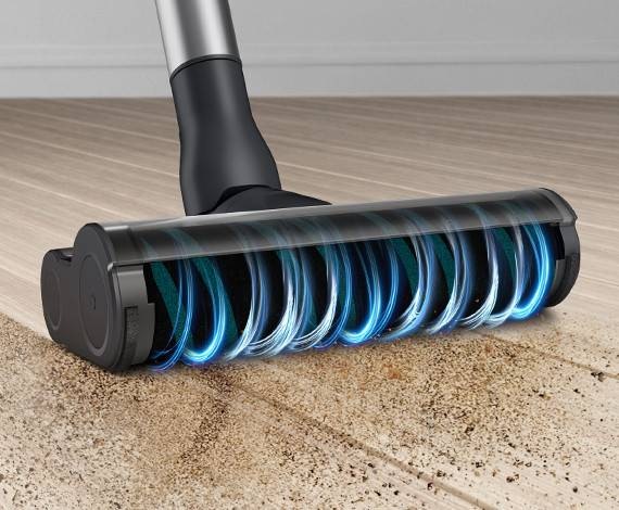 We zien een close-up van de Samsung Jet-stofzuiger met de Soft Action Brush om vuil van een vloer te reinigen.