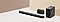 Een soundbar, twee rear speakers en een subwoofer staan voor een beige muur.