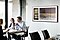 People are sitting at the table having a conversation while The Frame in Art Mode hangs on the wall