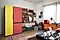 A BESPOKE refrigerator with bright yellow and red doors stands in a colorfully decorated living room filled with retro-style furniture