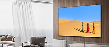 TV Samsung murale avec trois femmes marchant dans le désert tout en plaçant un pot sur leur tête.