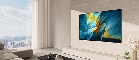 Un grand téléviseur OLED de Samsung est accroché au mur d'un salon moderne et lumineux.
