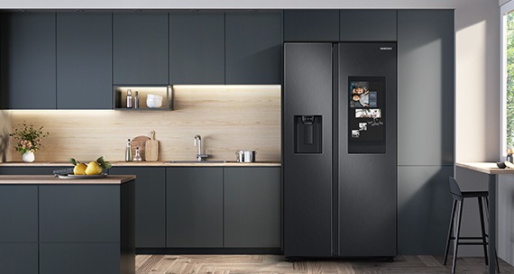 geladeira preta de duas portas numa cozinha com armários escuros