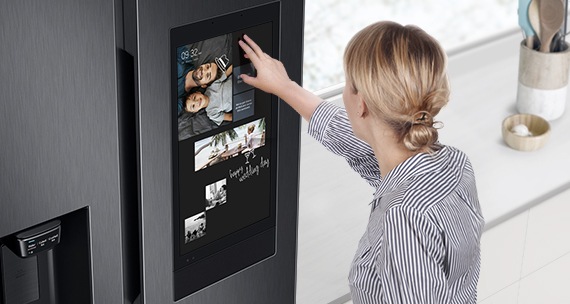 mulher loira mexendo na porta da geladeira smart