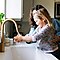 Mother and daughter washing hands in kitchen sink