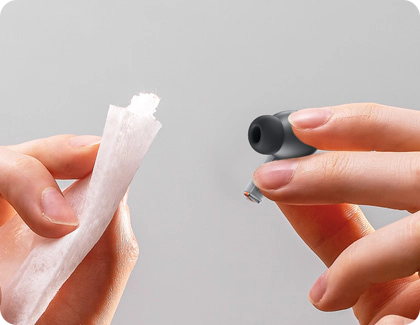 Someone is wiping the earbud tip of a Galaxy Buds3 Pro with a soft cloth.