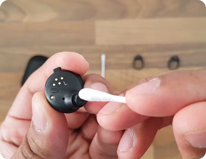 Gear IconX being cleaned with a cotton swab.