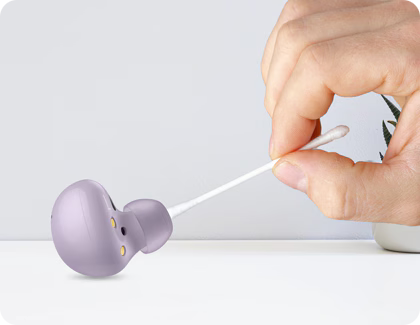 Galaxy Buds2 being cleaned with a cotton swab.