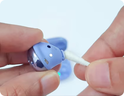 Galaxy Buds Pro being cleaned with a cotton swab.