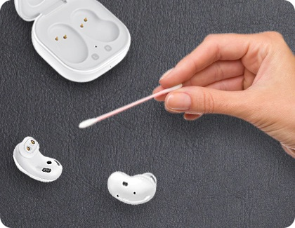 Galaxy Buds Live being cleaned with a Q-tip.
