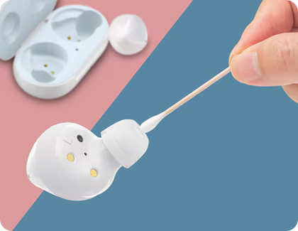 Galaxy Buds+ being cleaned with earbuds and case in the background.