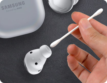 Cleaning Galaxy Buds with a cotton swab.