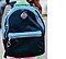 A close-up of a kid's dark blue backpack with a grey Samsung Galaxy SmartTag attached to it.