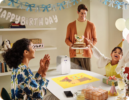 Une famille utilise le projecteur Premiere 5 pour projeter une image de fête d’anniversaire sur une table.
