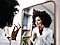 A lady looking in the mirror, she is applying something to her face