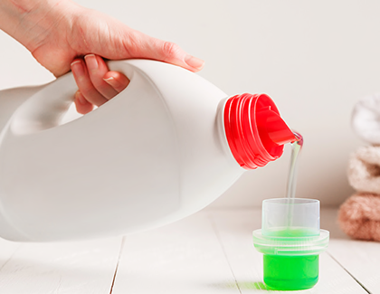 Person puring detergent into a cap